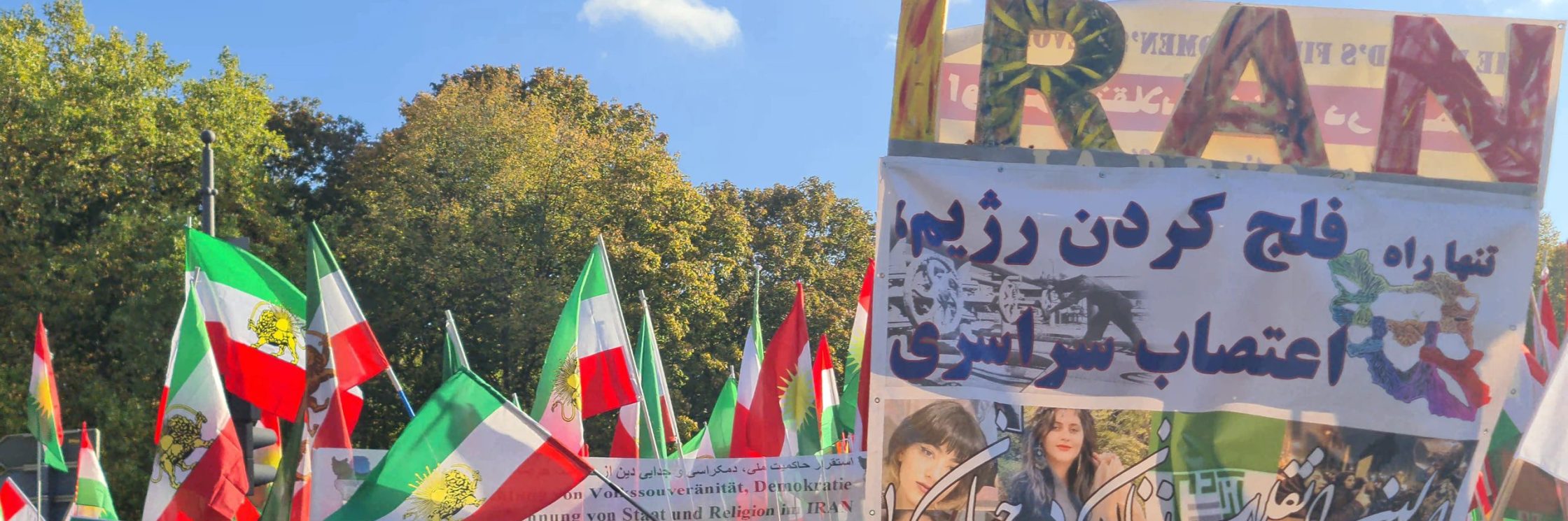 Menschen in einer Demonstration mit Iran-Fahnen und Schildern