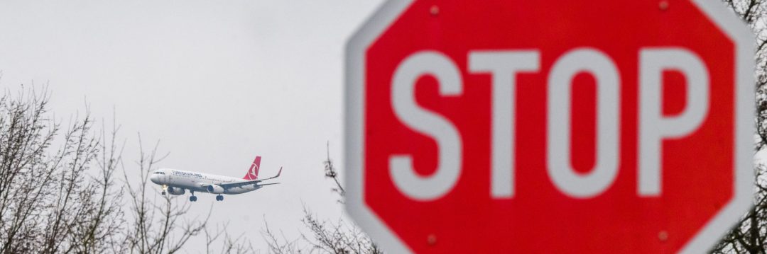 Flugzeug im Hintergrund, Stop-Schild im Vordergrund
